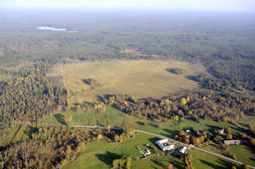 Flygbild på Lilla Attsjön innan återskapandet, visar en torrlagd sjö. Foto.