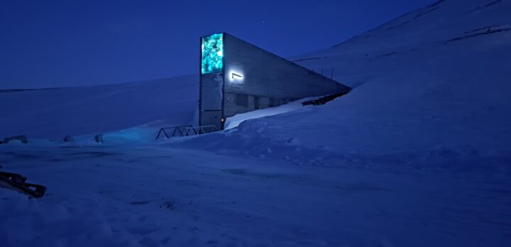 Ett snölandskap i ett skymningsblått ljus, en betongkonstruktion sticker upp. Foto.